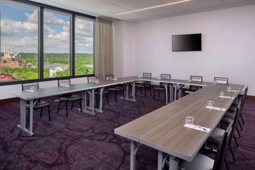 a conference room with tables and chairs and a flat screen tv at Hilton Rochester Mayo Clinic Area in Rochester