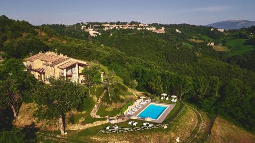 una vista aérea de una casa en una colina con piscina en Country House Ca'Balsomino en Urbino