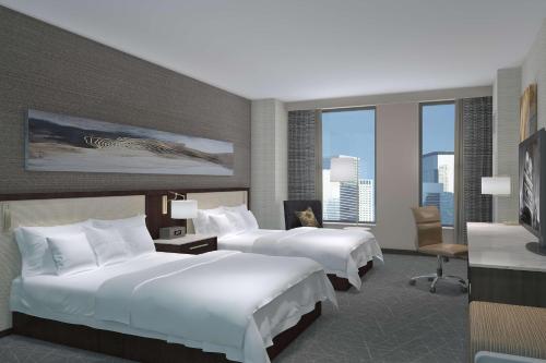 a hotel room with two beds and a large window at Hilton Rochester Mayo Clinic Area in Rochester