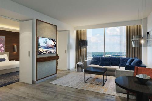 a living room with a couch and a tv at Hilton Rochester Mayo Clinic Area in Rochester