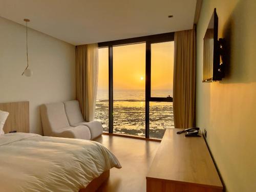 a bedroom with a bed and a view of the ocean at Les Roches De Mazagan in El Jadida