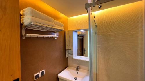 a bathroom with a shower and a sink and a mirror at Les Roches De Mazagan in El Jadida