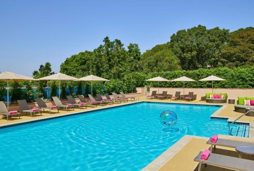 a pool with chairs and umbrellas at a hotel at Hilton Los Angeles North-Glendale & Executive Meeting Center in Glendale