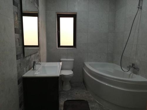 a bathroom with a tub and a toilet and a sink at Large 3 Bedroom Apartment in Pembroke 