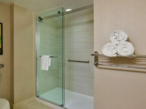 a bathroom with a glass shower with towels at Hilton Los Angeles North-Glendale & Executive Meeting Center in Glendale