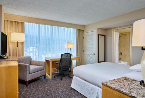 Hilton Los Angeles North-Glendale & Executive Meeting Center في غليندال: غرفة فندقية فيها سرير ومكتب وكمبيوتر