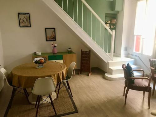 une pièce avec une table, des chaises et un escalier dans l'établissement Maison cosy nichée en bord de mer, à Villers-sur-Mer