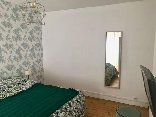 une chambre avec un lit et un miroir dans l'établissement Maison hypercentre et bord de mer, à Villers-sur-Mer