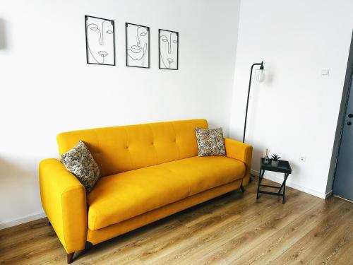 um sofá amarelo numa sala de estar com um candeeiro em Good Vibes Apartment em Sighetu Marmaţiei