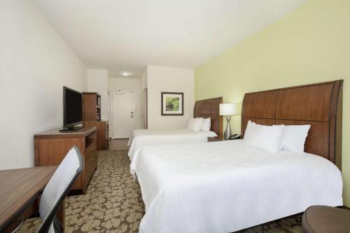 a hotel room with two beds and a television at Hilton Garden Inn Lincoln Downtown/Haymarket in Lincoln