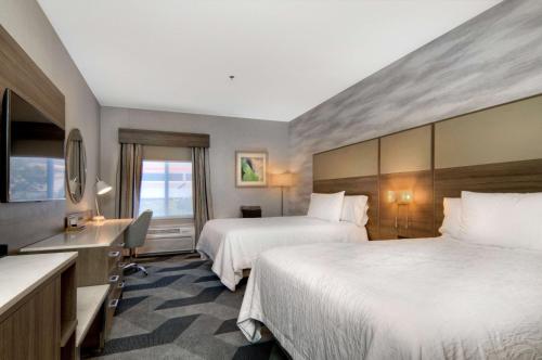 a hotel room with two beds and a desk at Hilton Garden Inn Livermore in Livermore