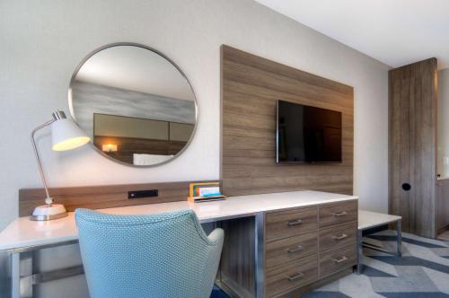 a room with a desk with a mirror and a chair at Hilton Garden Inn Livermore in Livermore