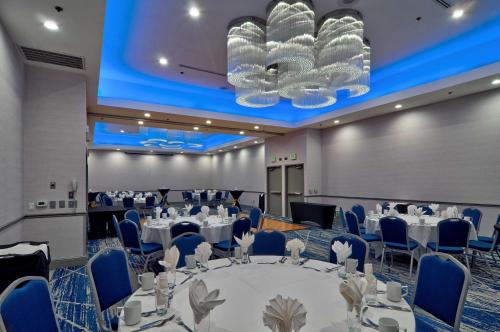 a banquet hall with tables and chairs and a large chandelier at Hilton Garden Inn Livermore in Livermore