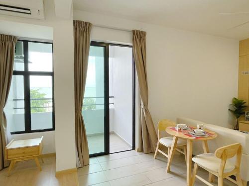 a living room with a table and a dining room at Mutiara Melaka Beach Resort by Minso in Tangga Batu