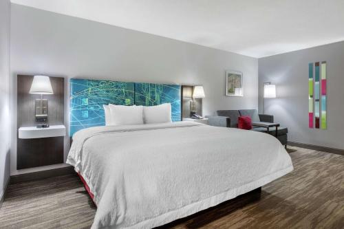 una habitación de hotel con una cama grande y una silla en Hampton Inn Brookhaven, en Brookhaven
