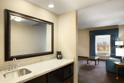 een hotelkamer met een wastafel en een spiegel bij Hampton Inn & Suites Aberdeen/APG South in Edgewood