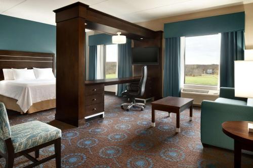 ein Hotelzimmer mit einem Bett und einem Schreibtisch in der Unterkunft Hampton Inn & Suites Aberdeen/APG South in Edgewood