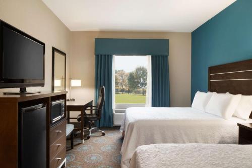 a hotel room with two beds and a flat screen tv at Hampton Inn & Suites Aberdeen/APG South in Edgewood