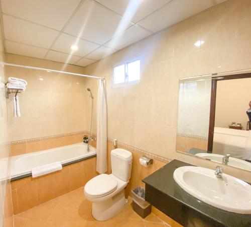 een badkamer met een toilet, een wastafel en een bad bij Bon Ami Hotel - Thiên Xuân Hotel in Ho Chi Minh-stad