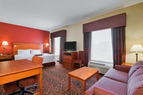 una camera d'albergo con letto, divano e scrivania di Hampton Inn Marion a Marion