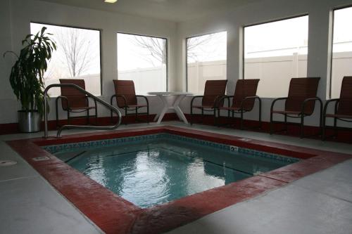 - une piscine avec des chaises et une table dans un bâtiment dans l'établissement Hampton Inn Salt Lake City/Murray, à Murray