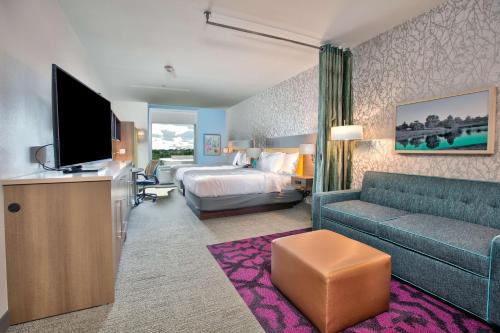 ウィチタフォールズにあるHome2 Suites By Hilton Wichita Falls, Txのベッドとソファ付きのホテルルーム