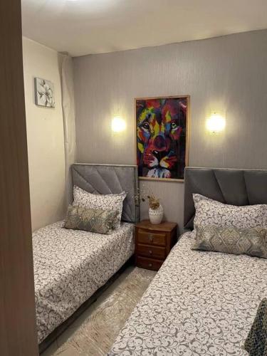 sypialnia z 2 łóżkami i obrazem na ścianie w obiekcie Appartement à louer w mieście Agadir