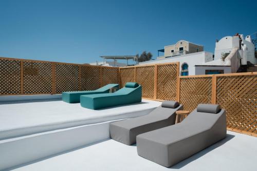 a rooftop patio with furniture and a fence at Marla Luxury Residences in Megalokhori