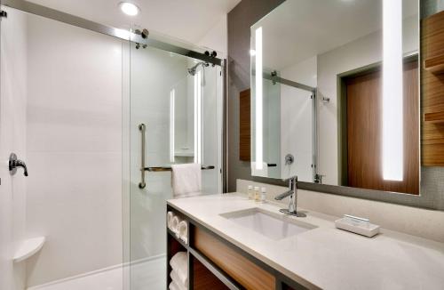 La salle de bains est pourvue d'un lavabo et d'un miroir. dans l'établissement Hilton Garden Inn Prescott Downtown, Az, à Prescott