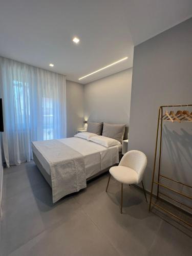 a bedroom with a large bed and a chair at CUORE - LUXURY ROOMS in Pescara