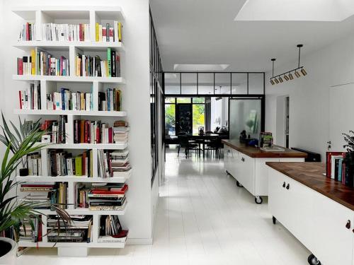 uma cozinha com prateleiras brancas cheias de livros em Loft House, Pool & Garden em Montreuil