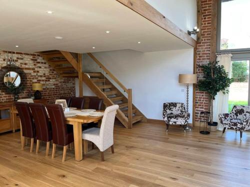 a dining room with a wooden table and chairs at Grange Farm Barn, Filby in Filby