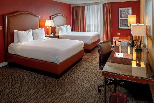 a hotel room with two beds and a desk at DoubleTree by Hilton Hotel St. Louis - Chesterfield in Chesterfield