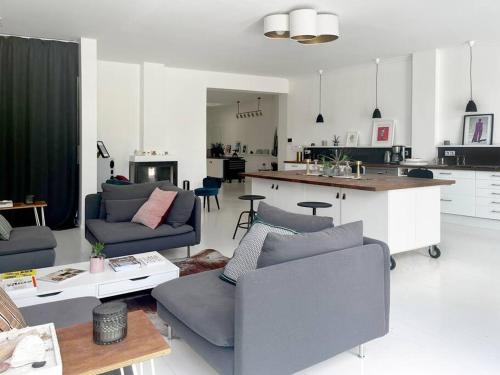 een woonkamer met 2 banken en een keuken bij Loft House, Pool & Garden in Montreuil