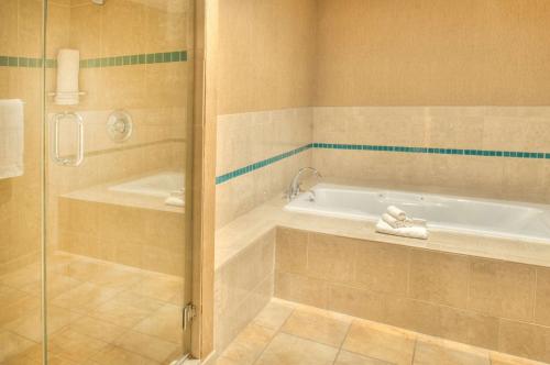 a bathroom with a bath tub and a shower at DoubleTree by Hilton Hotel St. Louis - Chesterfield in Chesterfield