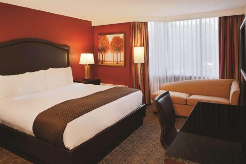 a hotel room with a bed and a chair and a desk at DoubleTree by Hilton Hotel St. Louis - Chesterfield in Chesterfield