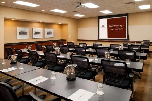 a conference room with tables and chairs and a screen at DoubleTree by Hilton Hotel St. Louis - Chesterfield in Chesterfield