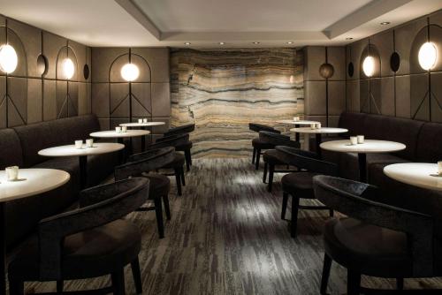 a restaurant with tables and chairs and a stone wall at LondonHouse Chicago, Curio Collection by Hilton in Chicago