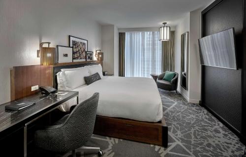 a hotel room with a bed and a desk and a desk at LondonHouse Chicago, Curio Collection by Hilton in Chicago