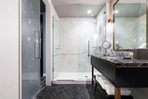 a bathroom with a glass shower and a sink at LondonHouse Chicago, Curio Collection by Hilton in Chicago