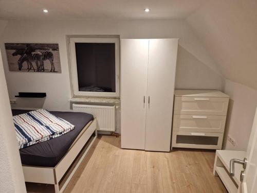 - une chambre avec un lit, une armoire et une fenêtre dans l'établissement Ferienhaus nahe Eckernförde, à Holzdorf