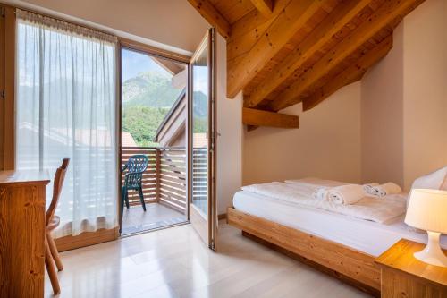 a bedroom with a bed and a balcony at Residenza Casale in Comano Terme