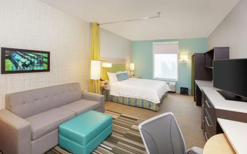 アマリロにあるHome2 Suites by Hilton Amarillo West Medical Centerのベッドとソファのあるホテルの部屋