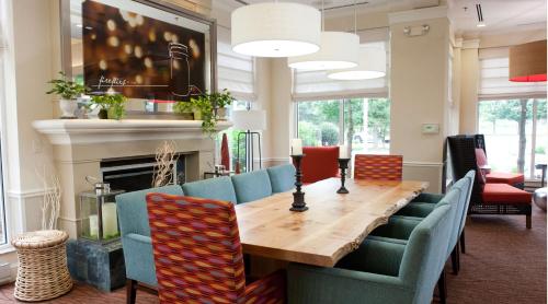 a dining room with a table and chairs and a fireplace at Hilton Garden Inn Secaucus/Meadowlands in Secaucus