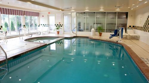 a large indoor pool with blue water in a building at Hilton Garden Inn Secaucus/Meadowlands in Secaucus