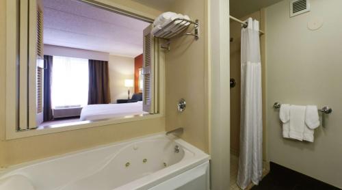 a bathroom with a tub and a large mirror at Hilton Garden Inn Secaucus/Meadowlands in Secaucus