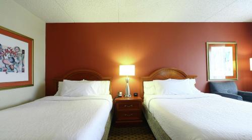 a hotel room with two beds and a chair at Hilton Garden Inn Secaucus/Meadowlands in Secaucus