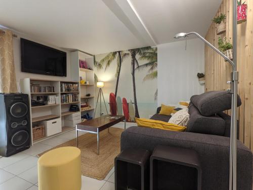 un salon avec un canapé et une télévision dans l'établissement Studio indépendant, accès piscine, au Castellet