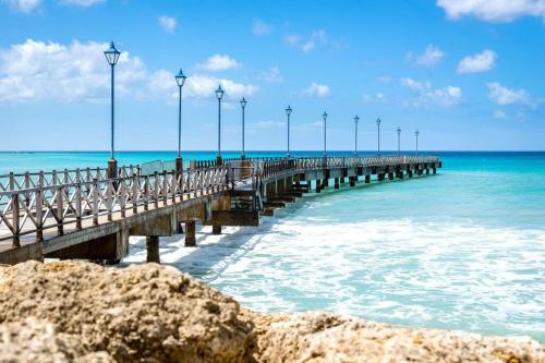 a pier on the ocean with lights on it at Spinnaker, #127 Port St. Charles Marina, Speightstown - Waterfront Luxury in Saint Peter