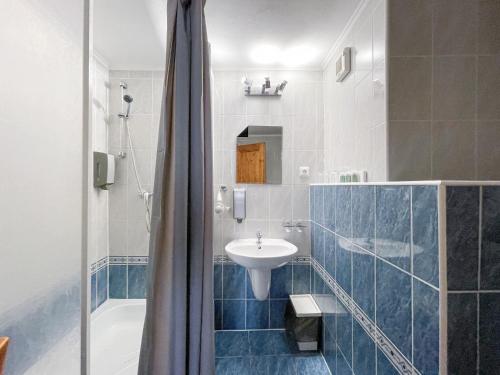 ein Bad mit einem Waschbecken und einer Dusche in der Unterkunft Penzion Portus in Bratislava
